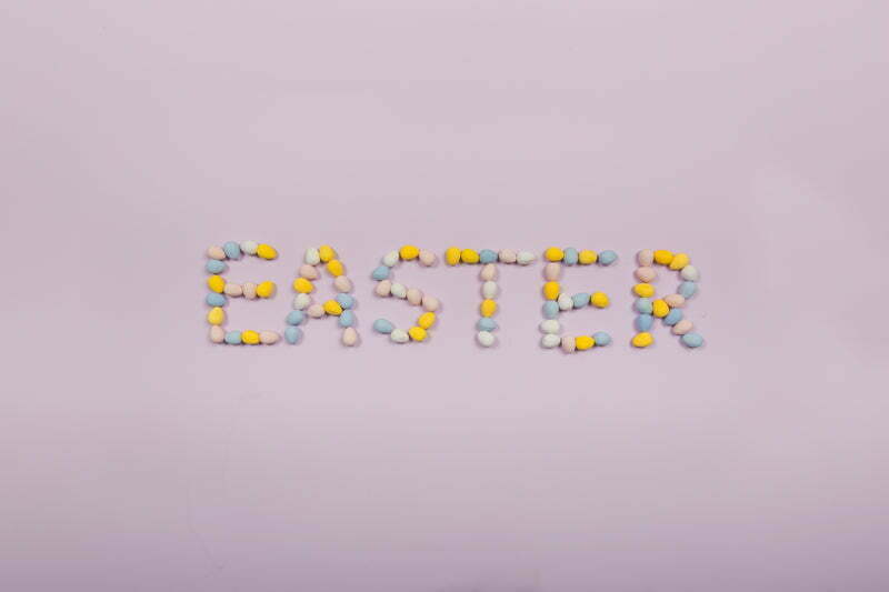 easter written in chocolate eggs on purple background